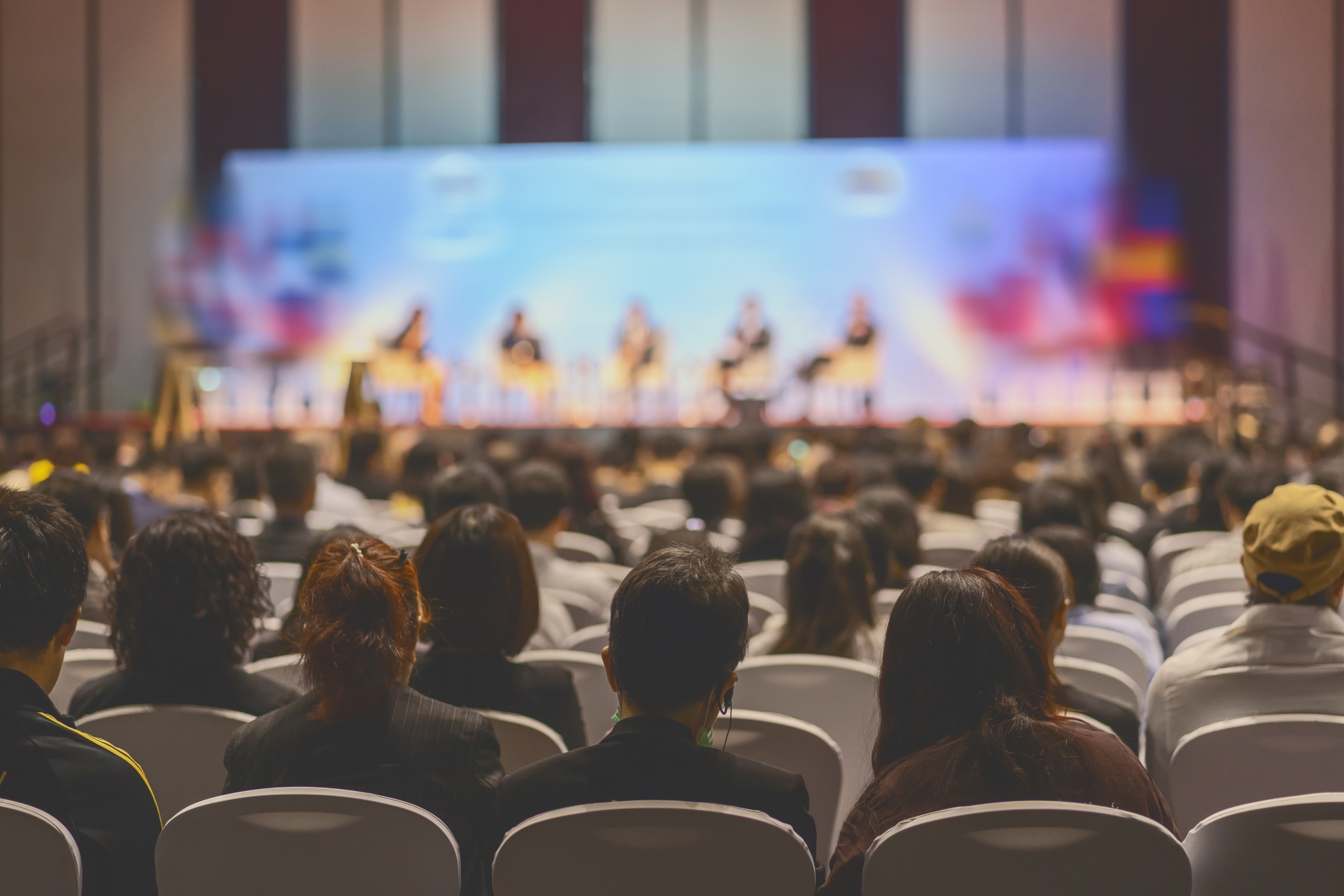 Rear view of Audience listening Speakers on the stage in the conference hall or seminar meeting, business and education about investment concept